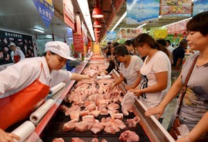 マーケットで豚肉を買い求める人々