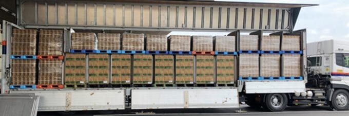 トラックの荷台に積まれたアサヒ飲料と日清食品の商品