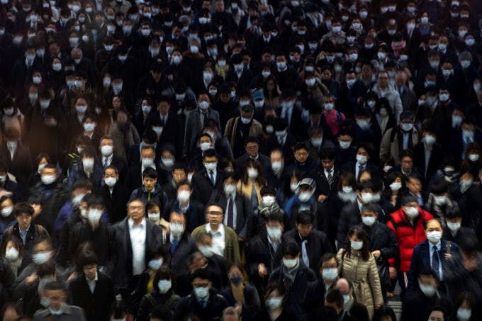 ラッシュ時の東京・品川駅rを歩くマスク姿の通勤客
