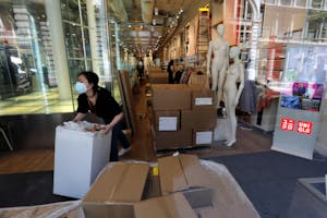 NYマンハッタンのユニクロの店内で梱包された商品を移動させている従業員