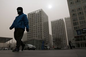 北京を歩くマスク姿の配達員