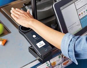 「アマゾン・ワン」の専用端末で手のひらをかざして決済する様子