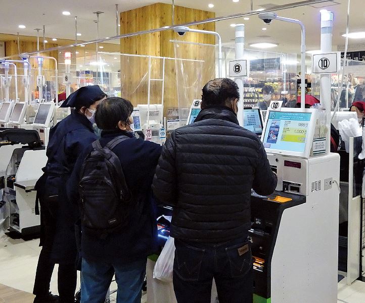 セルフレジで支払いをする買い物客