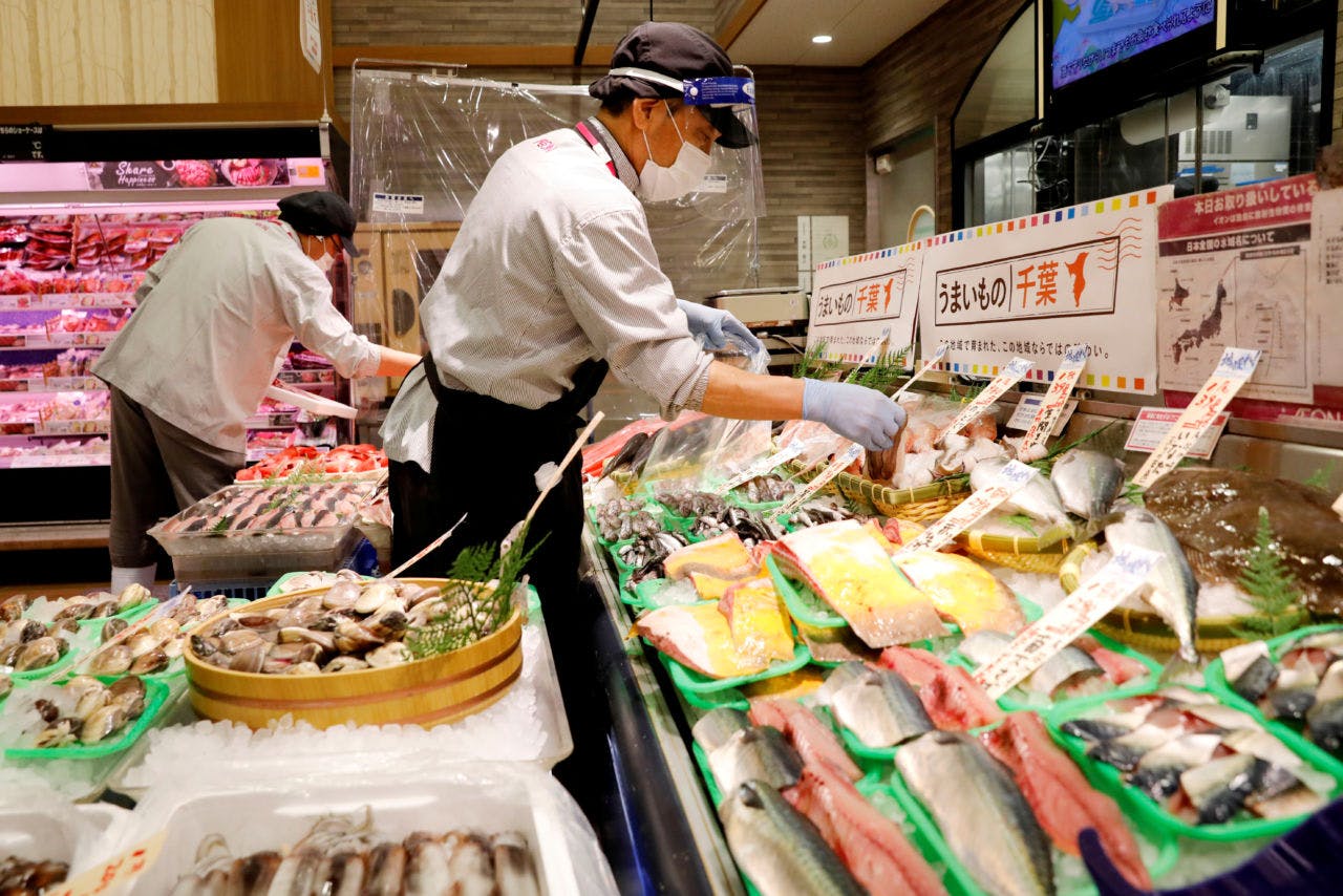 フェースシールドを着用して対応する魚売り場の店員