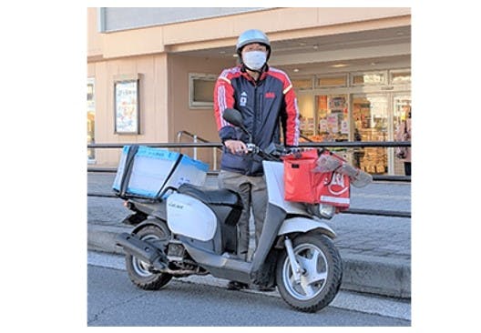 京急ストア京急鶴見店から商品を配達する朝日新聞の配達員