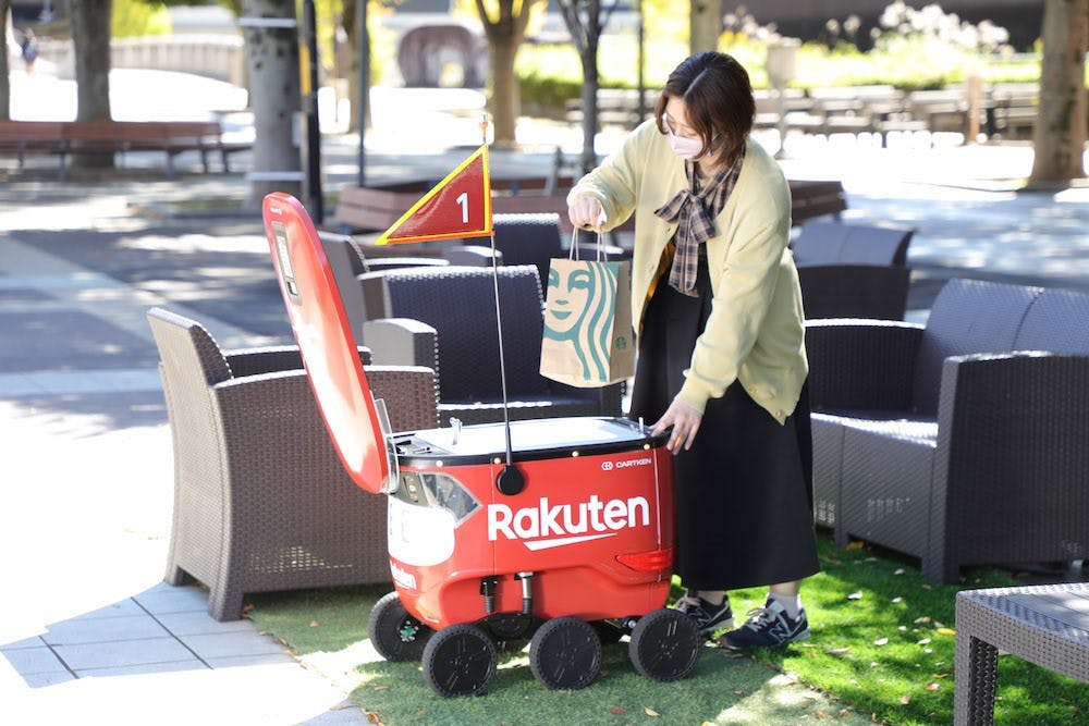 楽天の自動配送ロボットから商品を受け取る利用者