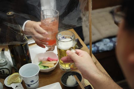 焼き鳥店で乾杯する人たち