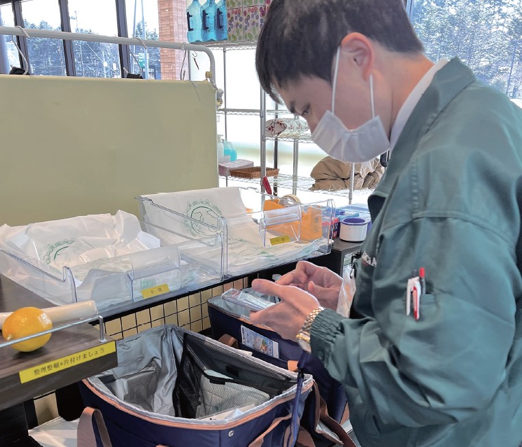 デリシアのバックヤードでスマホを用いて商品管理を行う様子