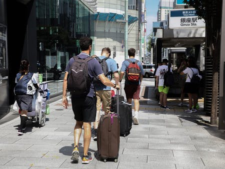 スーツケースを手に東京・銀座を歩く外国人観光客