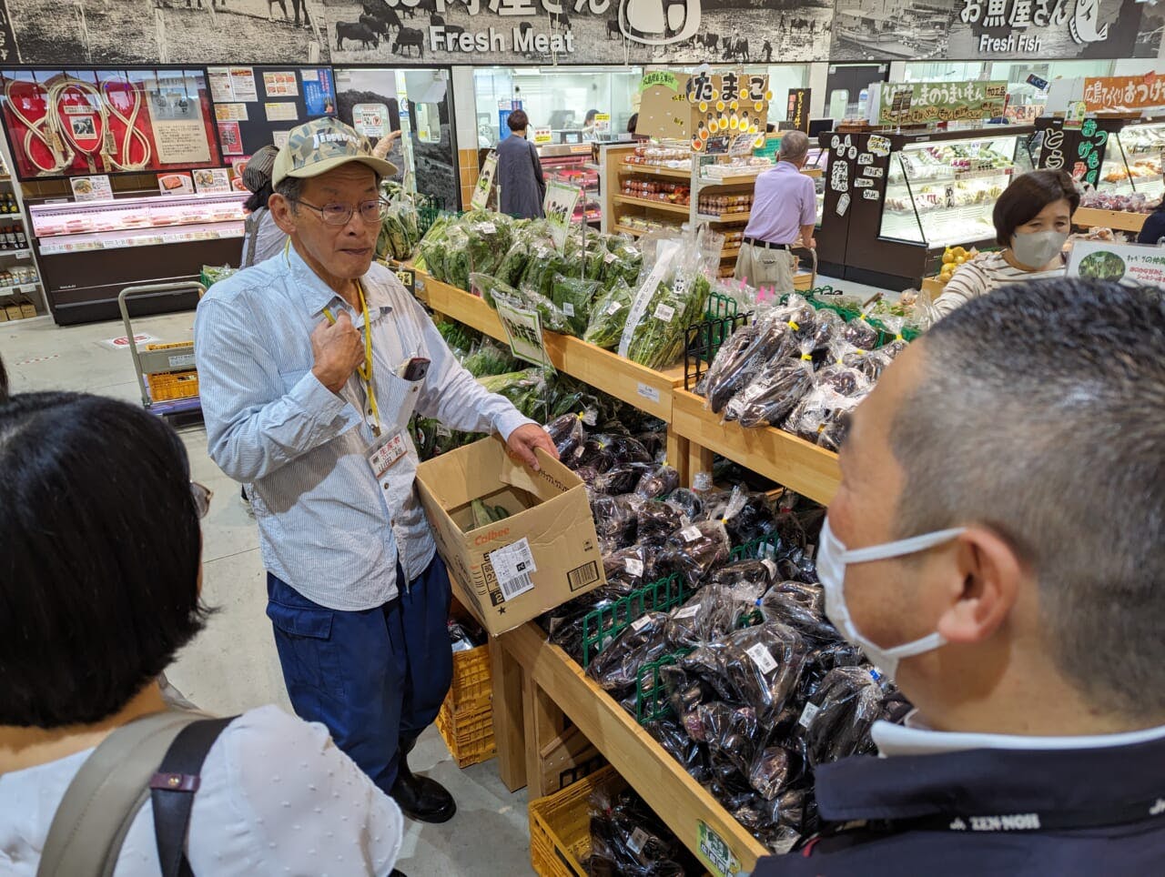 店頭で店舗従業員と談笑する山田さん