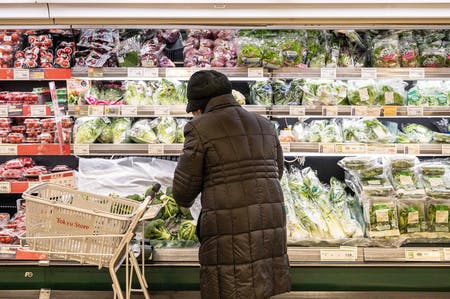 スーパーの野菜売り場で買い物する人