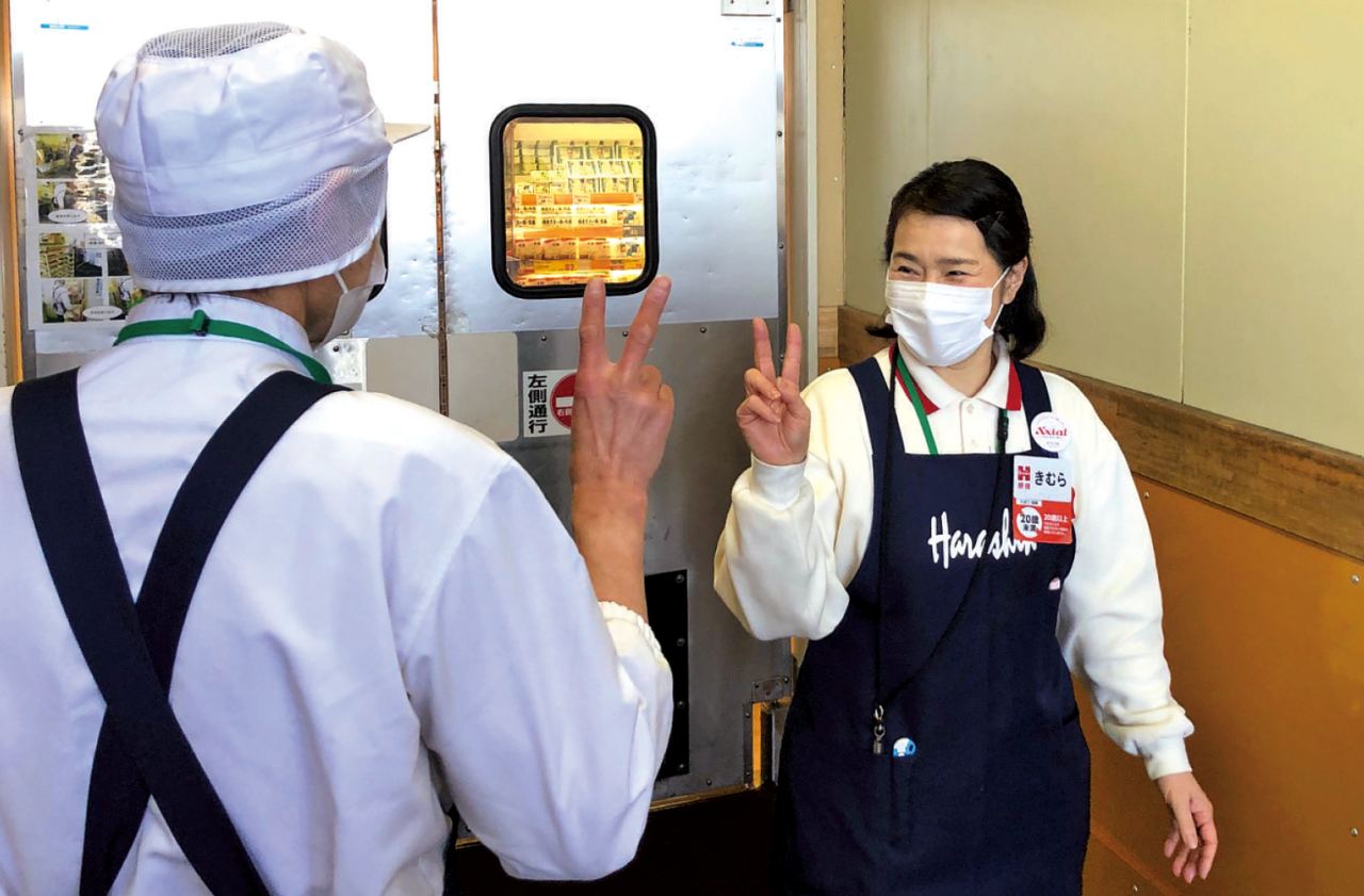 従業員がハンドサインを送っている様子