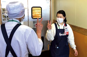 従業員がハンドサインを送っている様子