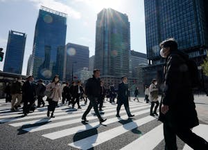 東京都内の横断歩道を渡る通勤客ら