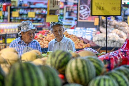 中国　スーパーの青果売り場で買い物をする男性客