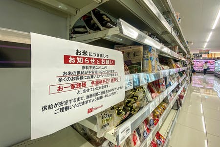 空になったスーパーのコメ売り場に掲示された張り紙