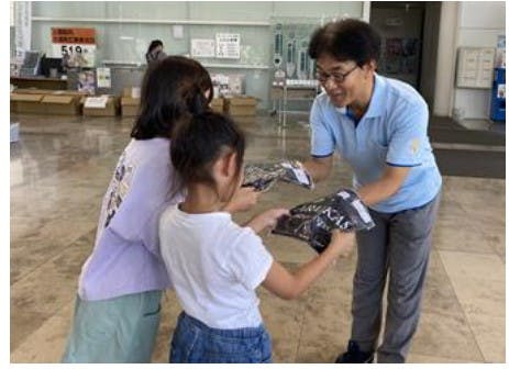 マルエツの「衣類バンク」で提供された衣類を子どもたちに手渡す様子