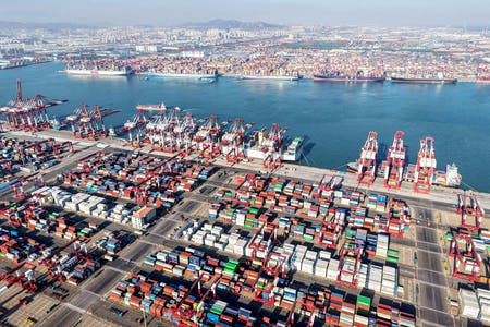 中国・山東省青島市の港に並ぶコンテナと巨大クレーン