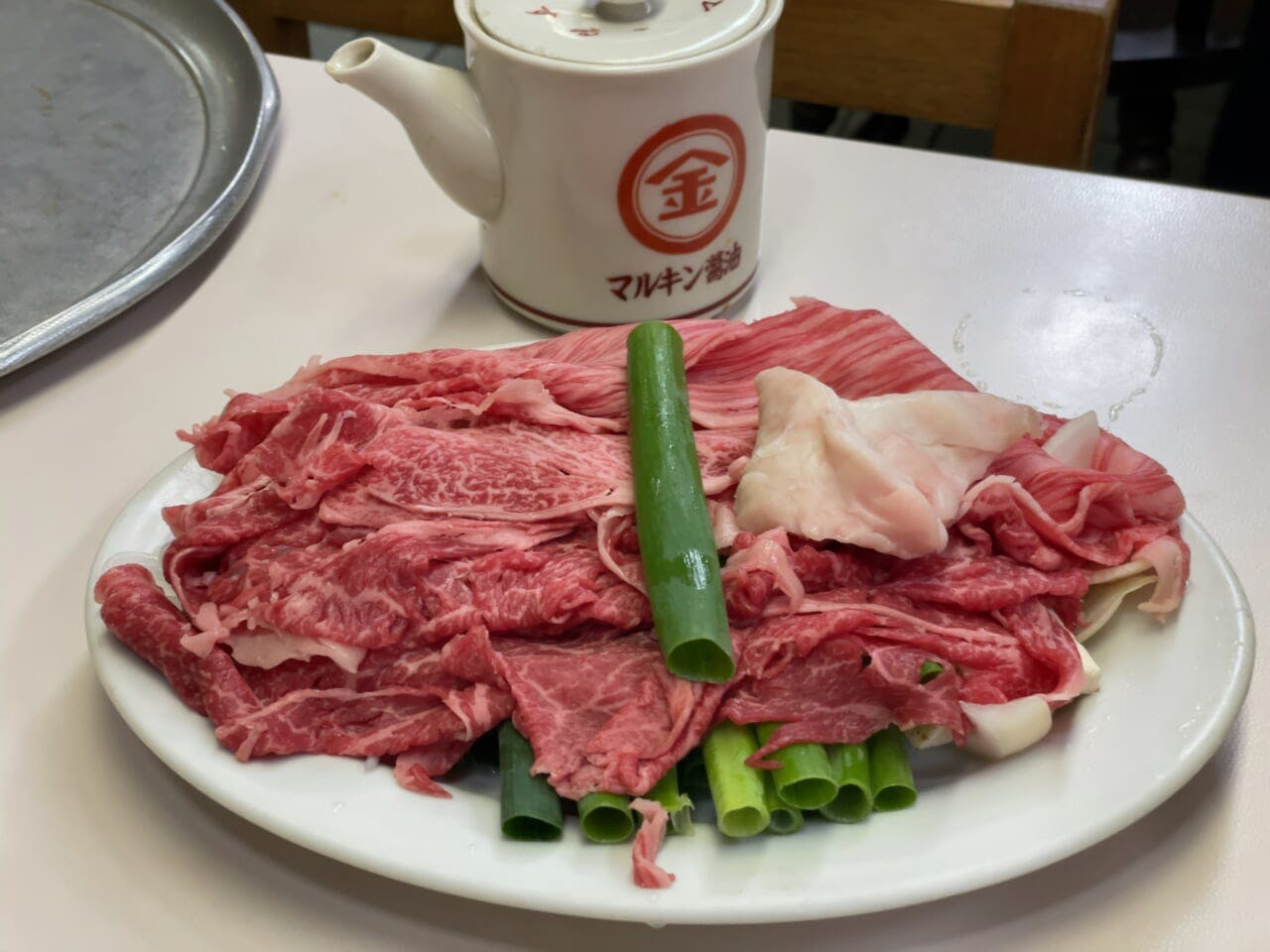 牛肉、青ネギ、糸こんにゃく（しらたき）、豆腐などが盛られた皿
