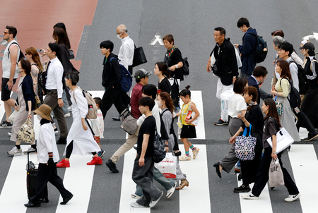 東京・新宿地区の横断歩道を渡る歩行者