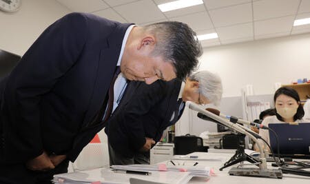 消費期限偽装問題について記者会見し、頭を下げるミニストップの堀田昌嗣社長（左）とイオンの渡辺広之副社長