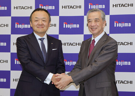 記者会見で握手するノジマの野島広司社長（右）と日立製作所の網谷憲晴執行役専務